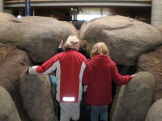 Mensen, op de rug te zien, bij hunebed